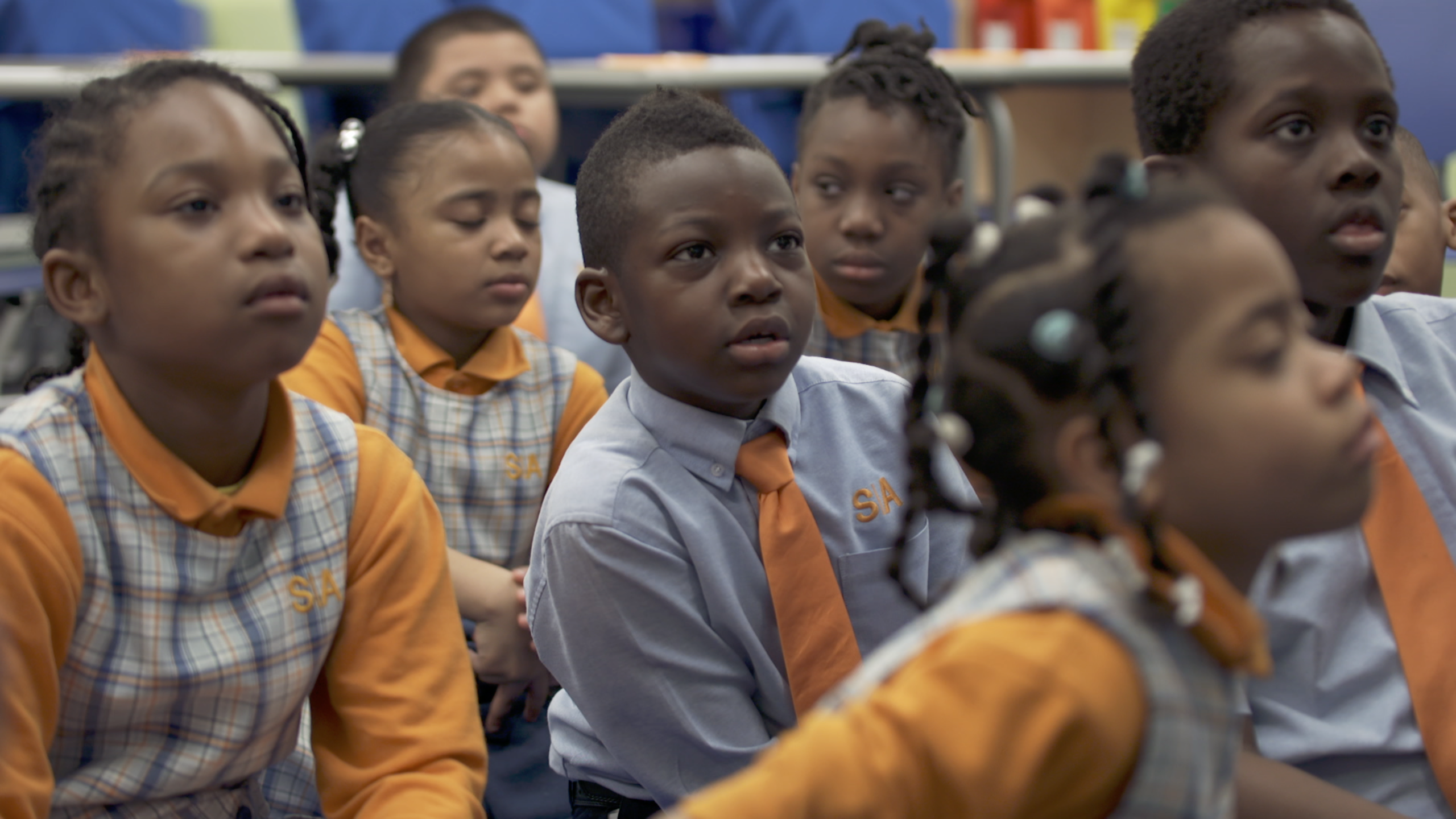 A group of young students focusing ahead in success academy