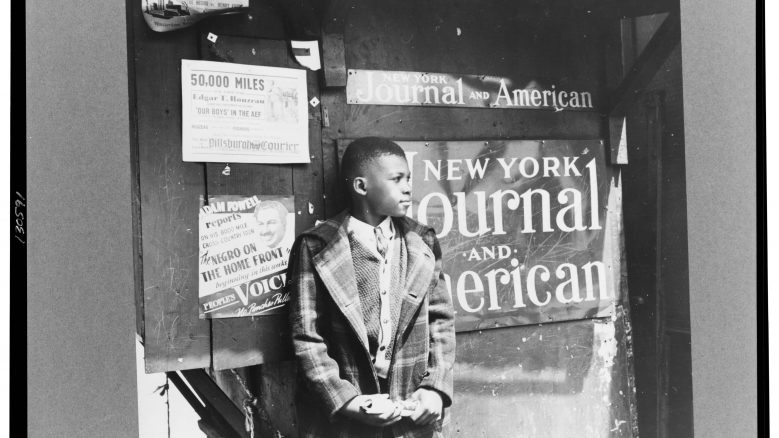 A black and white photograph of a Harlem newsboy (1943)