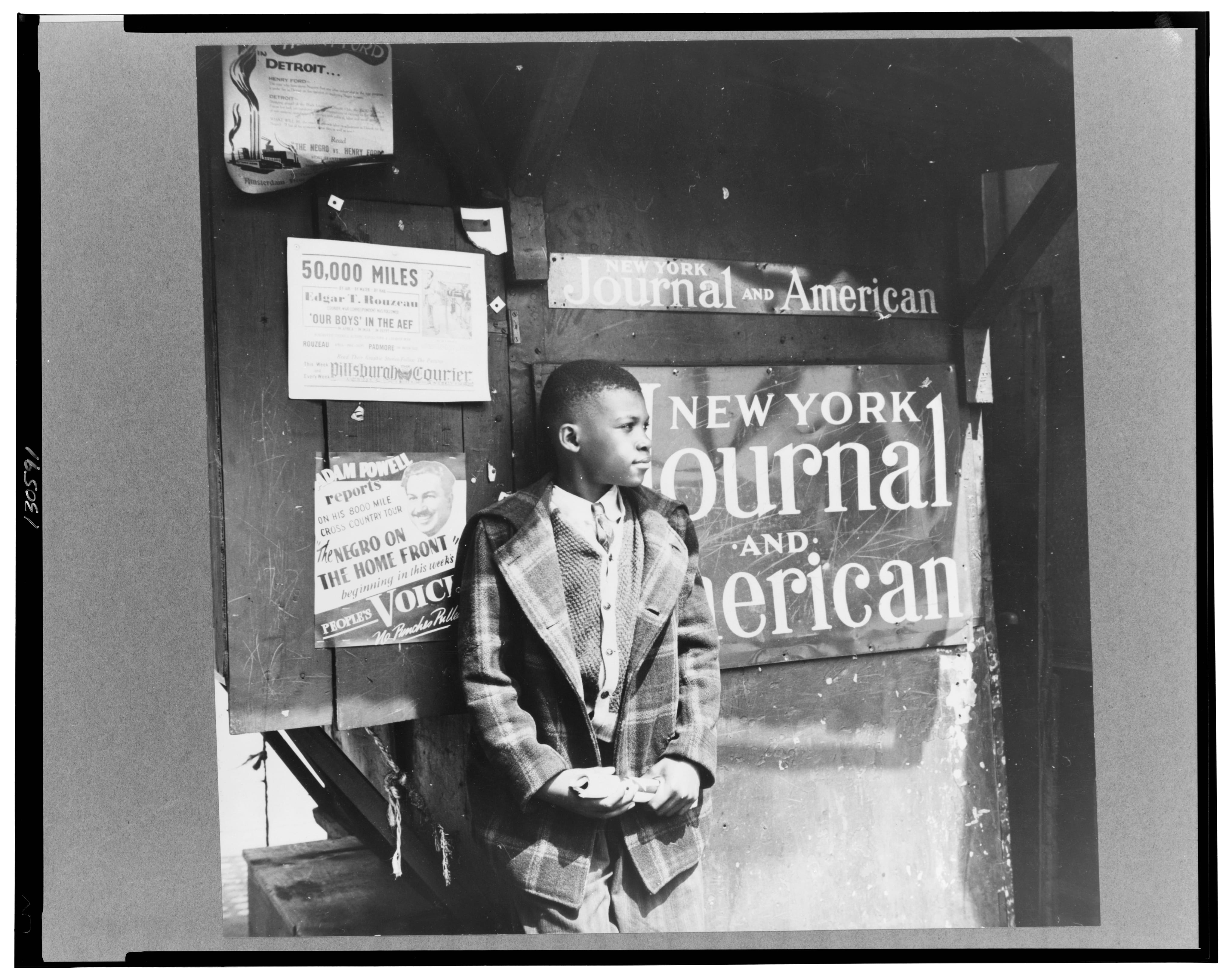 A black and white photograph of a Harlem newsboy (1943)