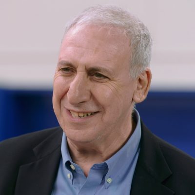 Portrait of Edward Hirsch in a suit and smiling.