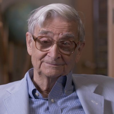 Portrait of E.O Wilson wearing a suit and smiling.