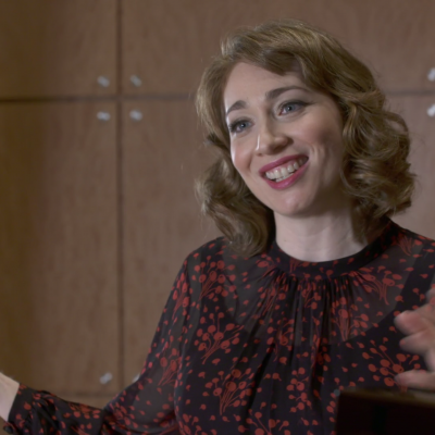 Portrait of Regina Spektor smiling and gesturing with hands.