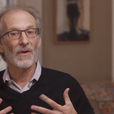 Portrait of Richard Summers in mid-speech and gesturing with hands.