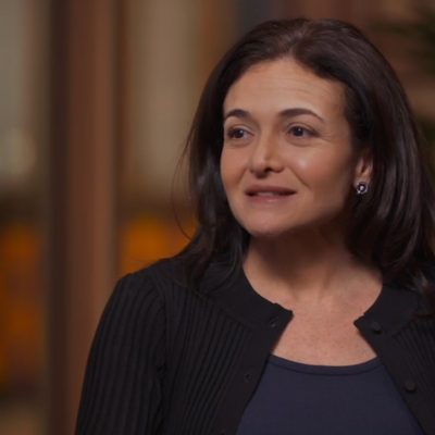 Portrait of Sheryl Sandberg wearing a black top and smiling.