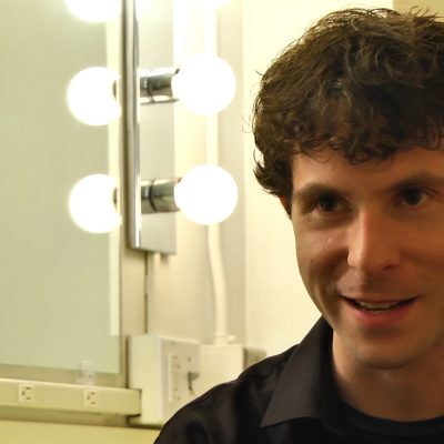 Portrait of Composer Matthew Aucoin smiling.