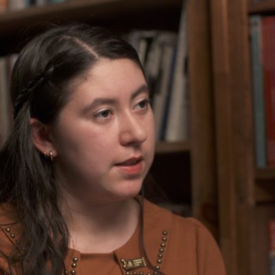 Portrait of a student, looking toward the side and in the middle of speaking.