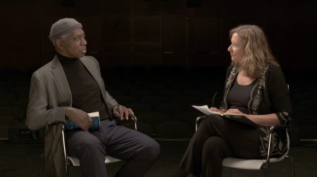 Yusef Komunyakaa seated and conversing with Elisa New.