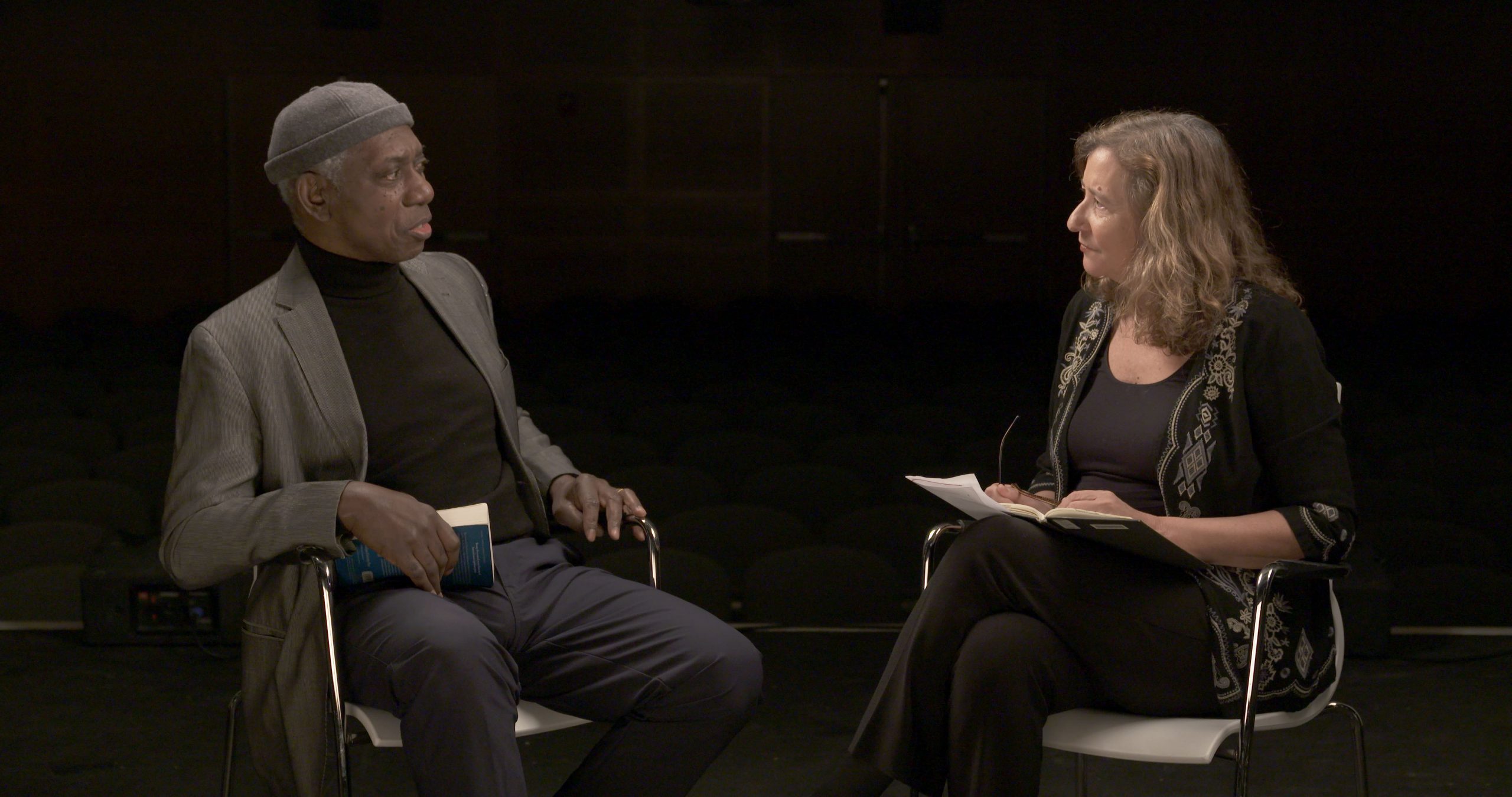 Yusef Komunyakaa seated and conversing with Elisa New.