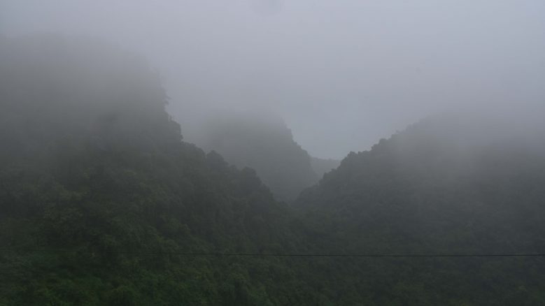 A landscape of fog-enshrouded mountains.