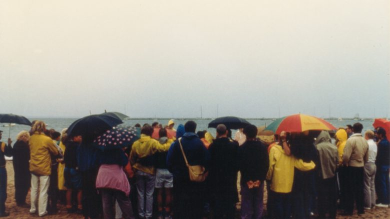 An AIDS memorial service in Provincetown on Cape Cod, depicting a group of people huddled together.