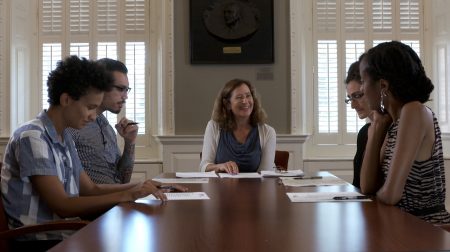 Elisa New sits with a group of graduate students at table