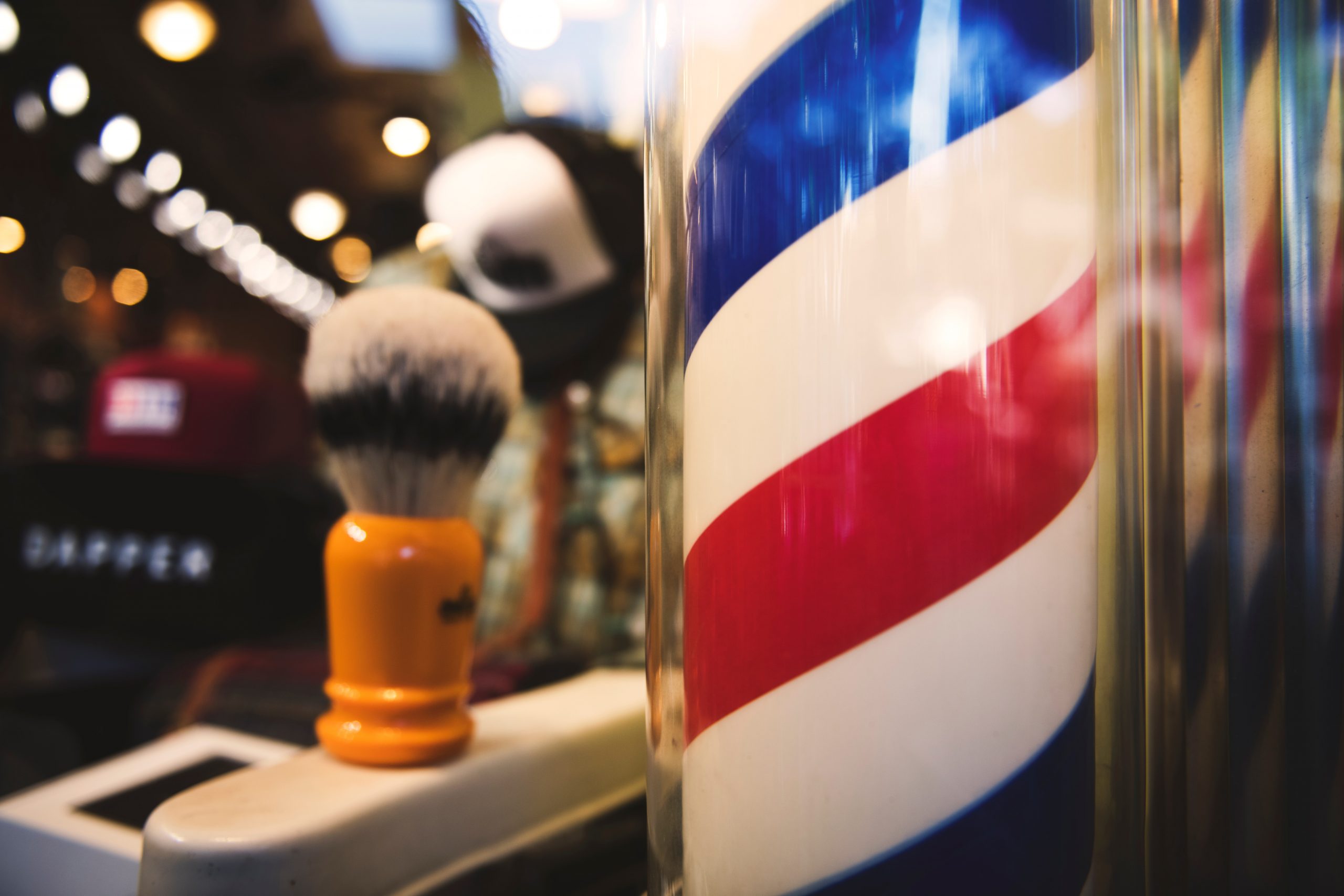 A classic barber pole with red, white, and blue stripes spiraling around it.