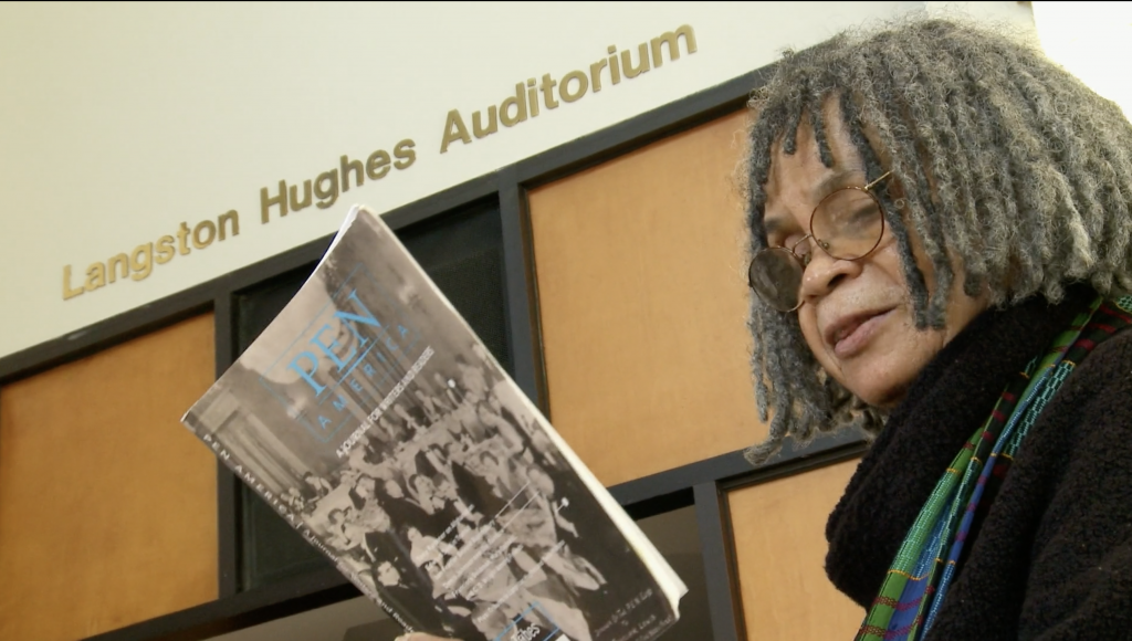 Sonia Sanchez reads from a book in her hand.