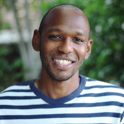 Headshot of Donald Brown smiling while wearing a striped shirt.