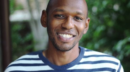 Headshot of Donald Brown smiling while wearing a striped shirt.