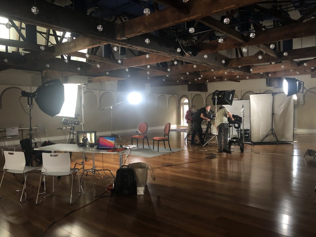 On the set at Planet Word Museum, numerous pieces of recording equipment are arranged, accompanied by chairs and tables.
