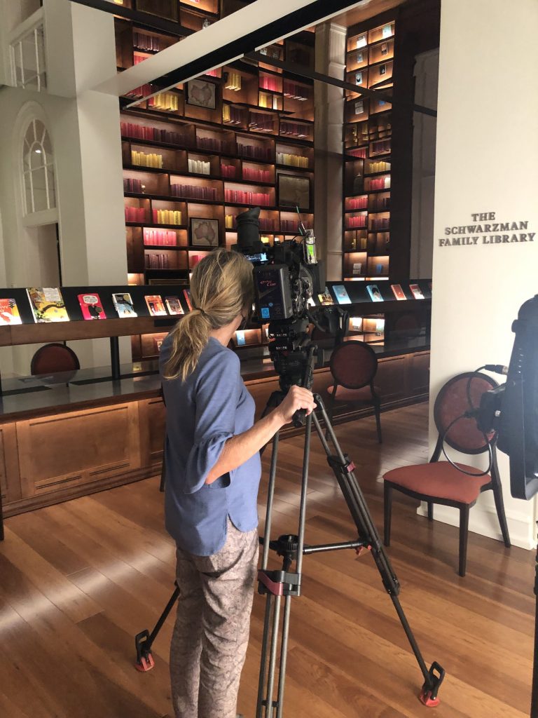 A crew member films the Schwarzman Family Library at Planet Word Museum