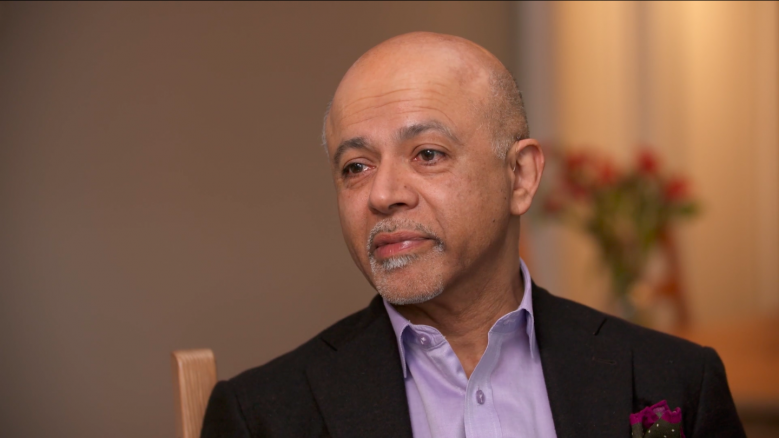 Portrait of Writer and Physician, Abraham Verghese, wearing a suit and looking off to the left.