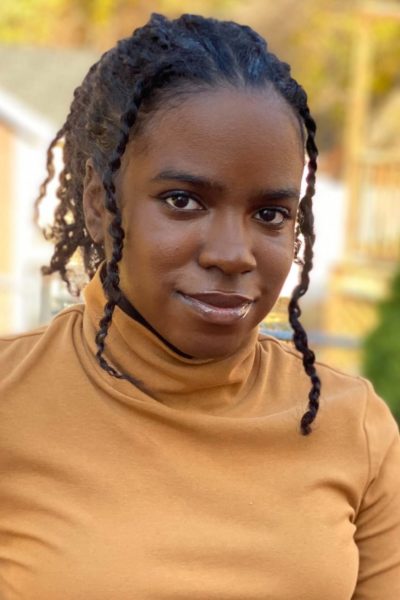 Portrait of Geraldine Joseph wearing a yellow turtleneck and smiling.