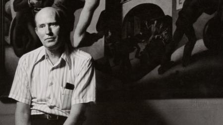 Black and white portrait of A.R. Ammons staring ahead while wearing a striped collared shirt.