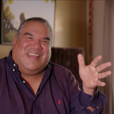 Filmmaker Chris Eyre, smiling while gesturing and in the middle of speaking