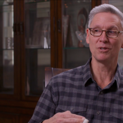 Historian Philip Deloria, wearing a button-up shirt, in the middle of speaking