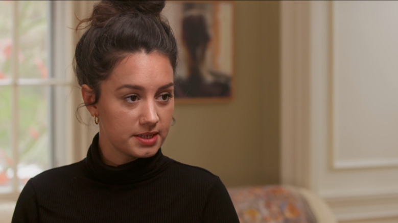 Poet Olivia Gatwood, wearing a black top, in the middle of speaking.