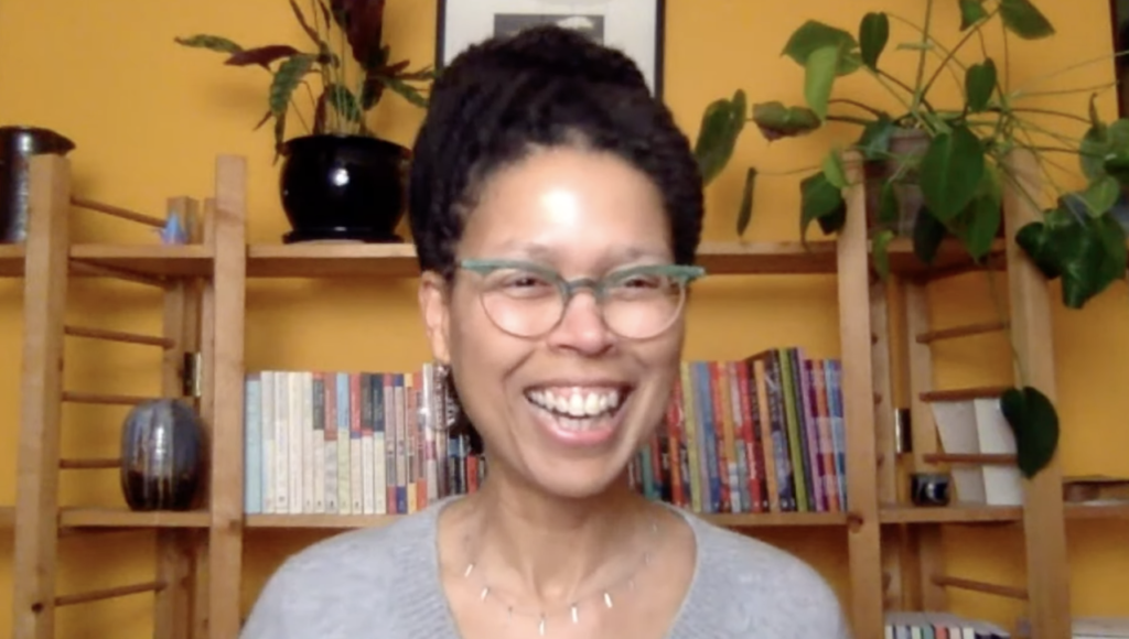 Evie Shockley smiles against a backdrop of bookshelves