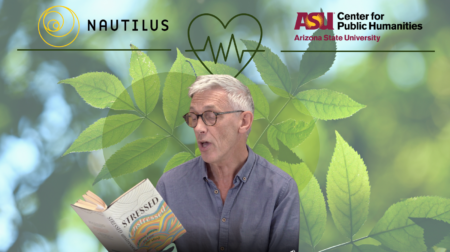 Sir Jonathan Bate reads from his anthology "Stressed, Unstressed: Classic Poems to Ease the Mind" against a green leafy backdrop.