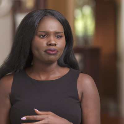 Suzannah Omonuk wears a black dress and gestures with her hands as she speaks.