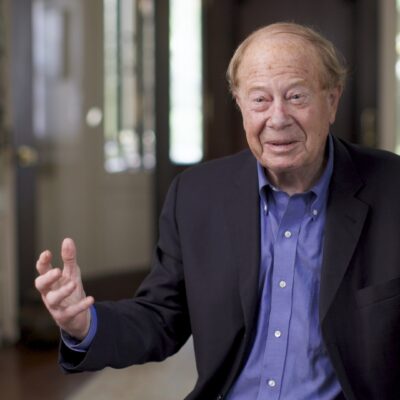 Joseph Ellis, wearing a suit, gestures with his hands as he speaks.