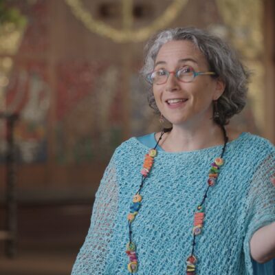 Rabbi Claudia Kreiman gestures with her hand as she speaks.