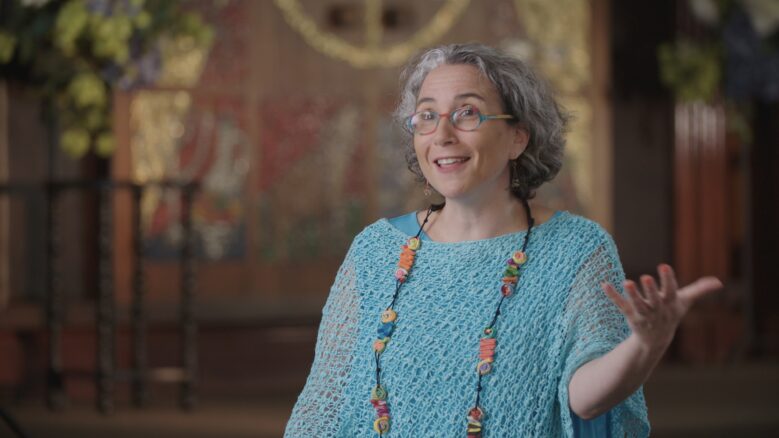 Rabbi Claudia Kreiman gestures with her hand as she speaks.