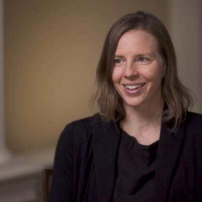 Louisa Thomas, wearing a black suit, smiles.