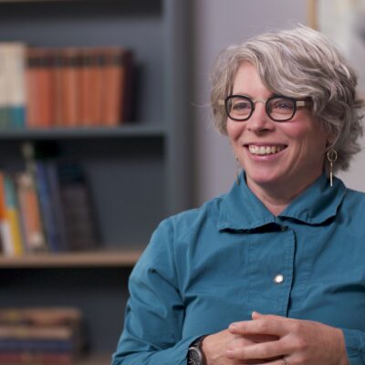 Jill Lepore smiles while wearing a teal button-up shirt